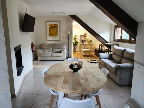 a living room with a table and a couch at Apartamento ático Belabarce in Isaba