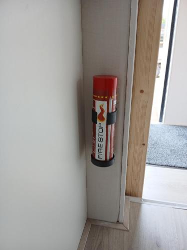 a fire extinguisher is in the corner of a room at Ruim en rustig chalet in Nationaal park de Drentsche Aa max 5 prs in Anloo
