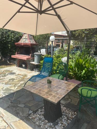 a table and chairs under an umbrella on a patio at Erifyli in Nea Kallikrateia