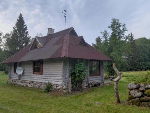 a small house with a tin roof on a field at Kikepera Alamaja in Parnumaa