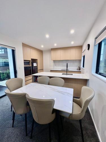 a kitchen with a white table and chairs at Modern 3BR Escape 3 Private Baths Rare Garage Perfect for Groups in Christchurch