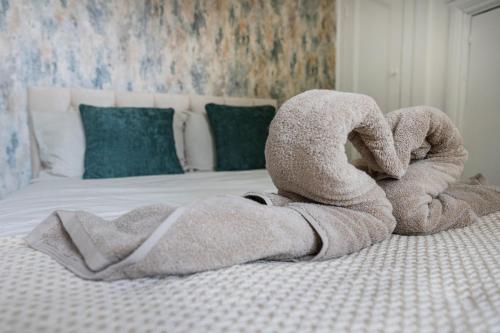 a stuffed animal shaped like a towel on a bed at Botanica convenient centre Stay free parking in Swindon