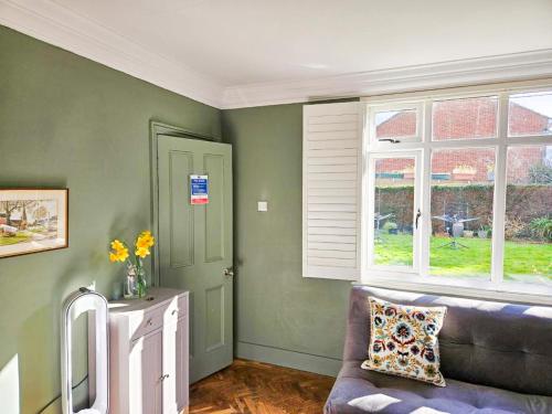 a living room with a couch and a window at The Lodge Stanwell in Stanwell
