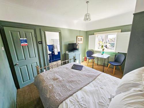 a bedroom with a bed with a laptop on it at The Lodge Stanwell in Stanwell