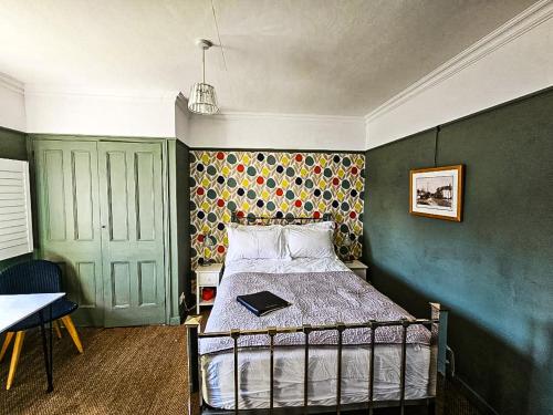 a bedroom with a bed with a book on it at The Lodge Stanwell in Stanwell