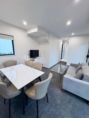 a living room with a table and a couch at Modern 3BR Escape 3 Private Baths Rare Garage Perfect for Groups in Christchurch