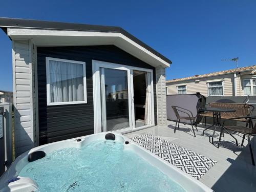 a hot tub on the patio of a house at Sunnymede B5 - Fantasy Island - HOT TUB, ramped decking, patio doors, central heating, pet friendly - Meadow Lakes Caravan & Lodge Hire in Ingoldmells