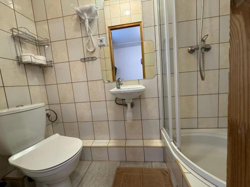 a bathroom with a toilet and a sink and a tub at Willa Modra in Bukowina Tatrzańska