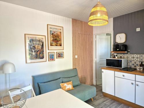 a living room with a blue chair and a table at Appartement proche de l'aéroport de Nantes in Saint-Aignan-Grand-Lieu