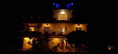 a large white building with a clock tower at night at Lotus Garden Guest House in Auroville