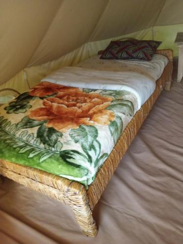a bed with a blanket with flowers on it at cyuza paradise island in Nyarugina