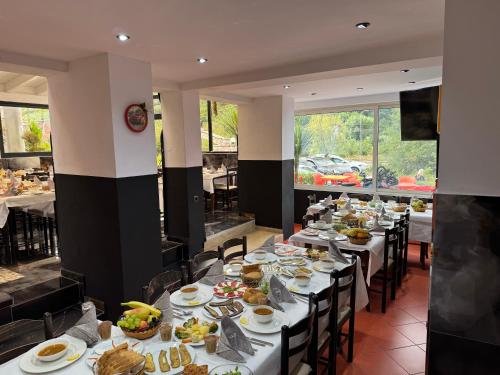 a dining room with long tables with plates of food at Hotel Bar Restaurant Mete in Peshkëpi
