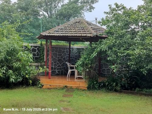 a gazebo with a chair in a yard at Nature Villa, Dukes Den Khandala in Khandala