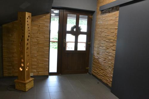 a hallway with a door and a brick wall at Apartmány Špacír in Harrachov
