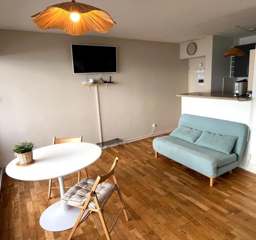 a living room with a couch and a table at STUDIO VUE IMPRENABLE SUR OCEAN in Lacanau