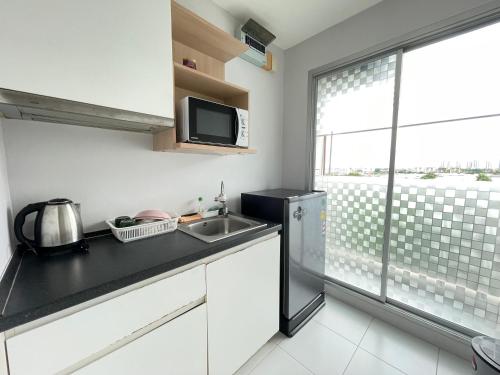 a kitchen with a sink and a refrigerator at Studio123 at changwattana in Ban Bang Phang
