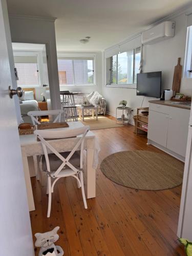 a kitchen and living room with a table and chairs at Paradise on Jones Beach Kiama - Beachfront unit with direct beach access & views in Kiama Downs