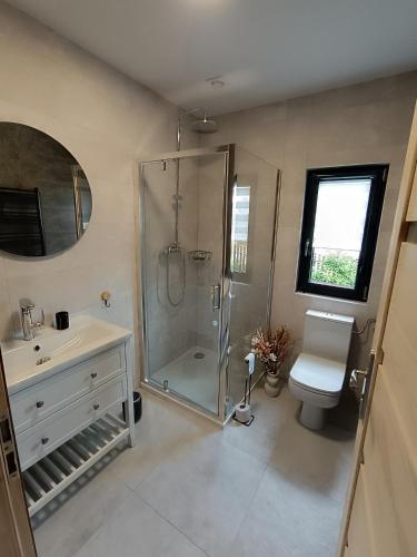 a bathroom with a shower and a toilet and a sink at Szumiące Drzewa in Debina