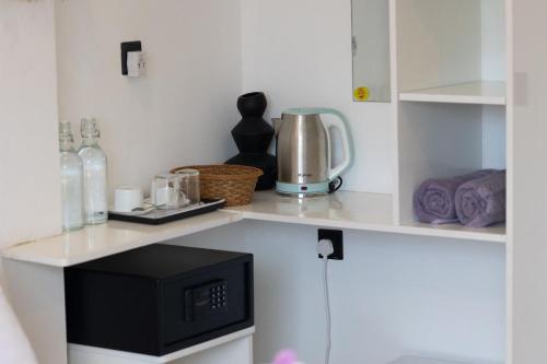 a kitchen with a counter top with a microwave at Sands Garden Hotel in Thoddoo