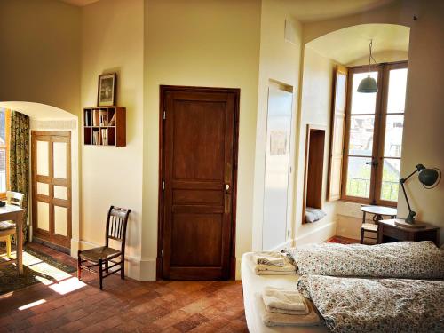 a bedroom with a bed and a wooden door at La Tour Beurdelaine in Avallon