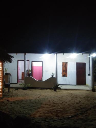 une maison blanche avec un toit bleu la nuit dans l'établissement Fr Resort, à Nikawatawana
