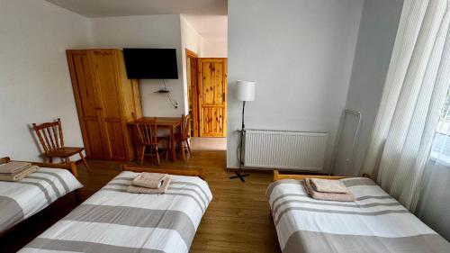 a room with three beds and a television in it at Pokoje Gościnne Lipowa in Czaplinek