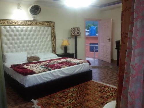 a bedroom with a large bed with a large headboard at Executive Heights Apartments in Bhurban