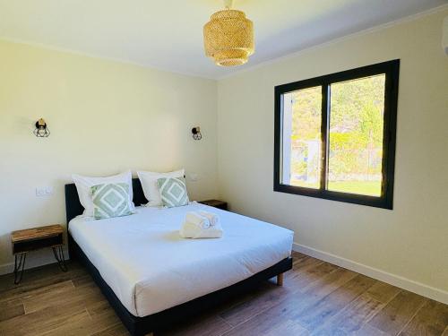 a bedroom with a large white bed with a window at L'Esprit Sud, 4 Suites & Piscine in Vence