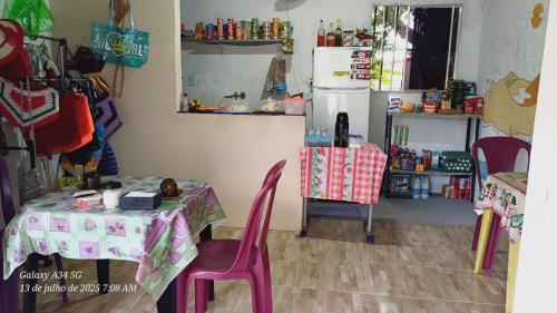 a kitchen with a table and chairs and a refrigerator at Brito Hospedagem in Barreirinhas