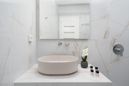 a white bathroom with a sink and a mirror at NEW Yiota Collection 4 Suites & 4 Prive Jacuzzi in Megalokhori