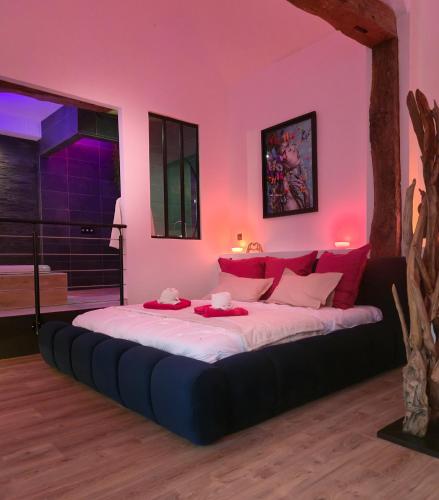 a bedroom with a large bed with pink walls at Mont Evasion Spa in Tanis