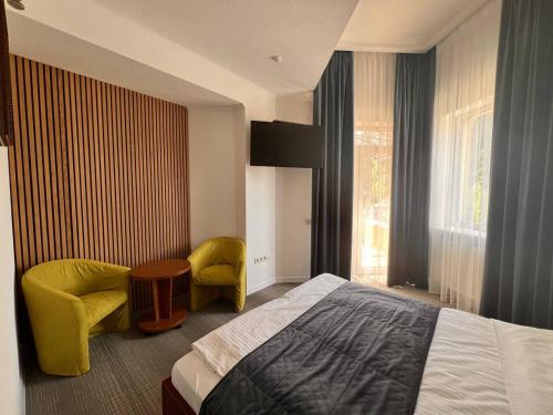 Un dormitorio con una cama y una silla y una ventana. en Gots - готельно-ресторанний комплекс, en Yaremche