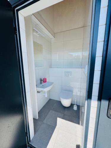 a bathroom with a toilet and a sink at Przyczepa Campingowa Loop it 30m od Zatoki Puckiej, Jastarnia in Jastarnia