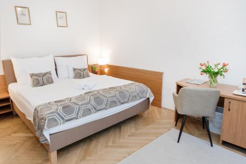 a bedroom with a bed and a desk and a chair at Hotel Anna Villa in Balatonföldvár