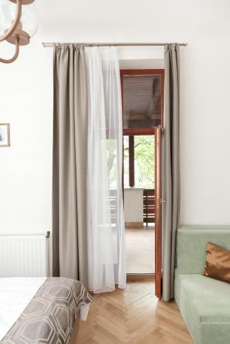 a bedroom with a bed and a sliding glass door at Hotel Anna Villa in Balatonföldvár