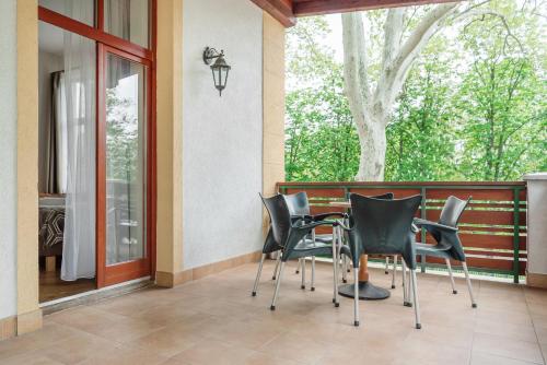 a group of black chairs sitting on a porch at Hotel Anna Villa in Balatonföldvár