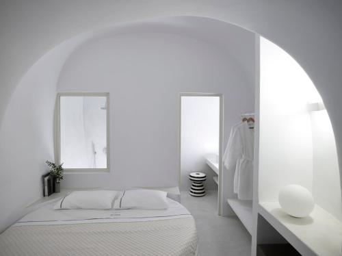 a white bedroom with a bed and two mirrors at Elegant Santorini House Villa Serenity Caldera Viewoutdoor Hot Tub Private Pool Oia in Thólos