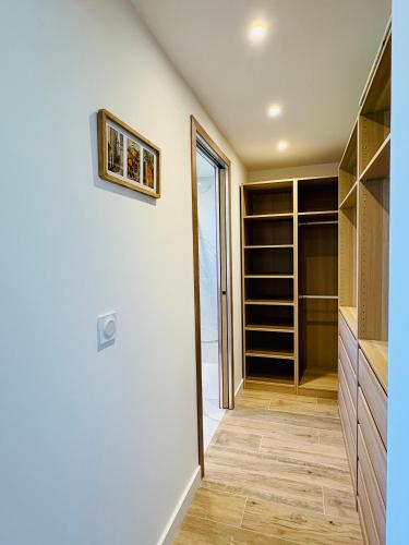 a walk in closet with wooden floors and a door at L'Esprit Sud, 4 Suites & Piscine in Vence