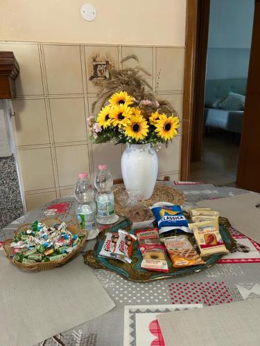 a table with food and a vase with sunflowers at Antica Casa Sabina in Torri in Sabina