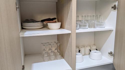 a cupboard filled with glass vases and dishes at Kay's Place Zanzibar in Zanzibar City