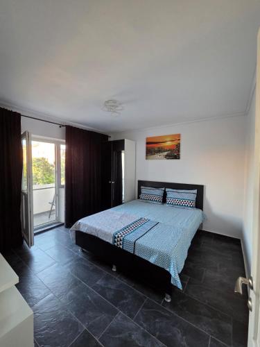 a bedroom with a bed in a room with a window at Apartament Milan in Mangalia