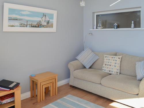 a living room with a couch and a table at Grays Cottage in Sewerby