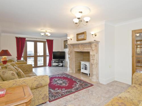 a living room with a fireplace and a couch at Magnolia Cottage in Aberaeron