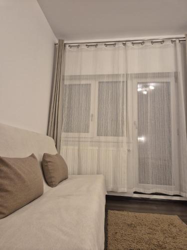 a bedroom with a bed and a window with curtains at Casa cu Flori in Buşteni