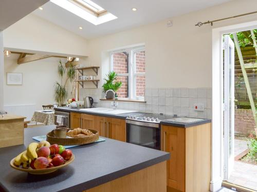 a kitchen with a bowl of fruit on a counter at The Coach House in Great Ryburgh