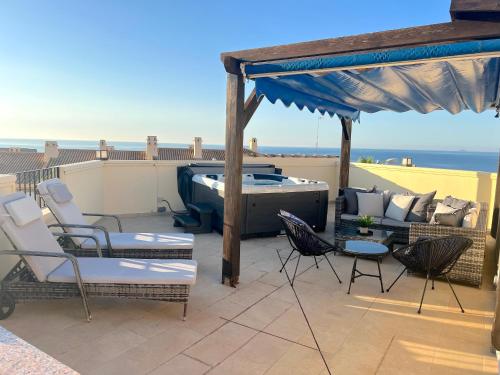 a patio with a hot tub and chairs on a roof at Penthouse & Jacuzzi With Sea Views In Costa Blanca in Orihuela