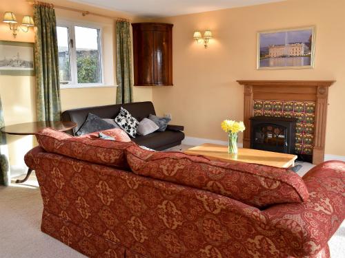 a living room with a couch and a fireplace at Grange Cottage in Winston