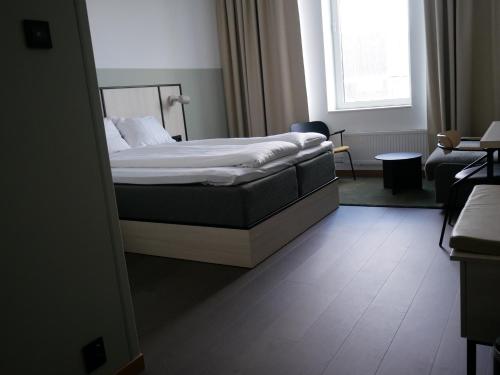 a bedroom with a bed and a living room at Comfort Hotel Norrköping in Norrköping
