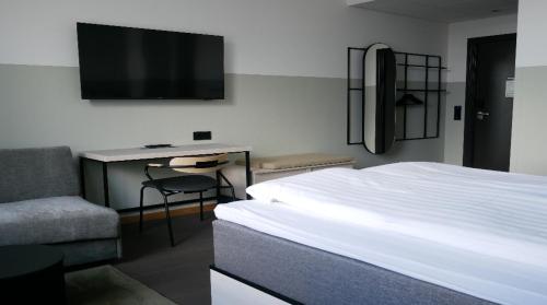 a bedroom with a bed and a desk and a tv at Comfort Hotel Norrköping in Norrköping