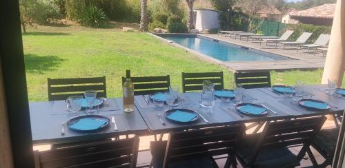 una mesa con copas y una botella de vino en Villa Callochiusa avec piscine 15mn Bonifacio, en Figari